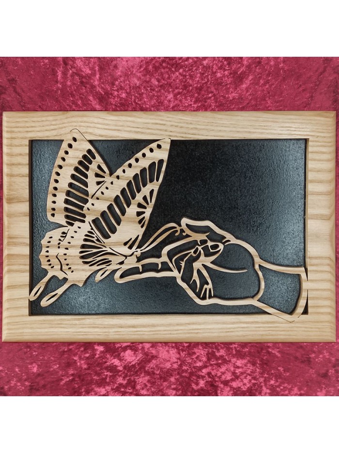 Tableau en bois noble d'un joli papillon posé sur un doigt
